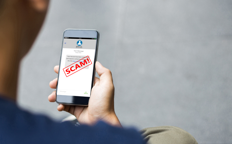 Smart phone in man's hands shown from behind him where the smart phone says that he was scammed